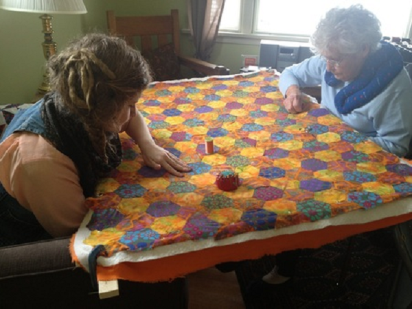 Girl quilting with grandma